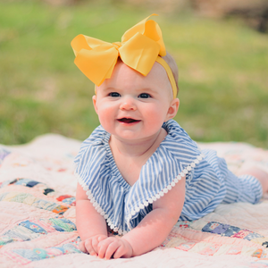 A baby laying on their stomach in tummy time outdoors